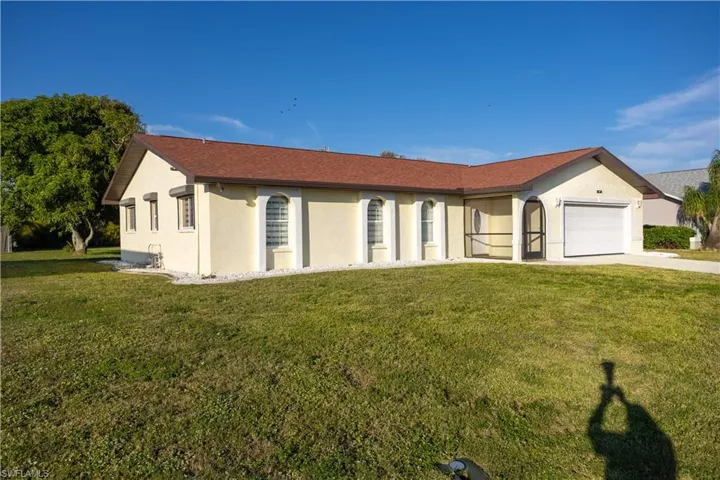 Ranch-style home featuring a garage and a front yard