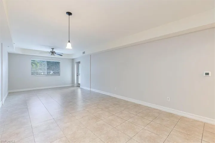 Unfurnished room featuring light tile patterned flooring and a ceiling fan