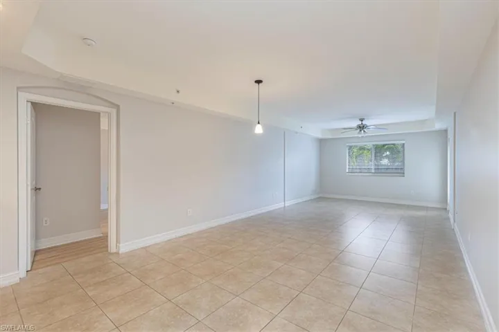 Empty room featuring light tile patterned flooring and ceiling fan