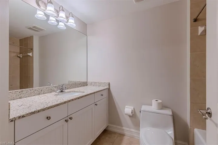 Full bath featuring vanity, light tile patterned floors, and shower / bathtub combination