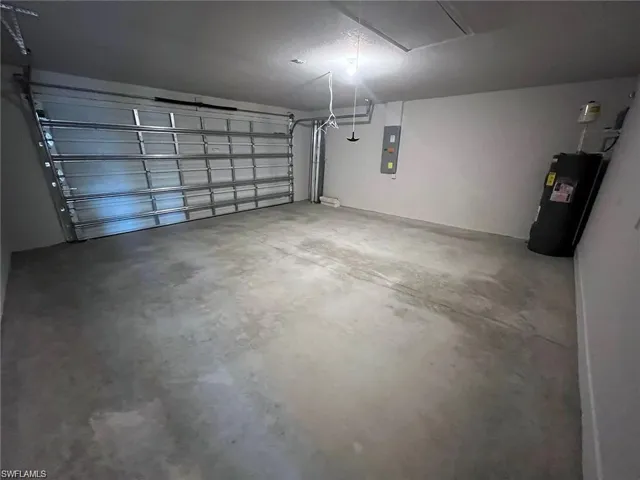 Garage featuring water heater and electric panel