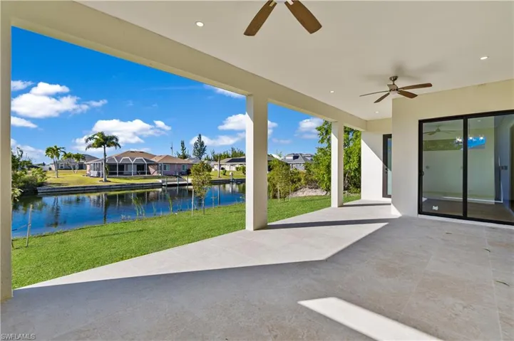 View of patio with a ceiling fan, a residential view, and a water view