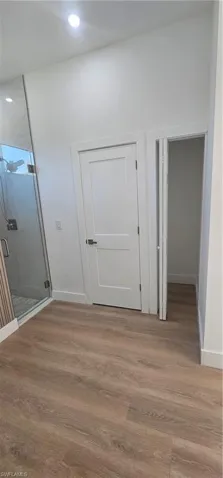Spare room with a raised ceiling, light wood-style flooring, ceiling fan, and recessed lighting