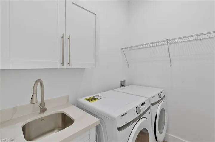 Laundry area featuring separate washer and dryer and cabinet space