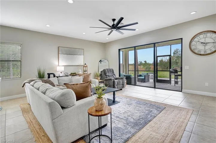 Living room with light tile patterned floors, plenty of natural light, recessed lighting, and ceiling fan