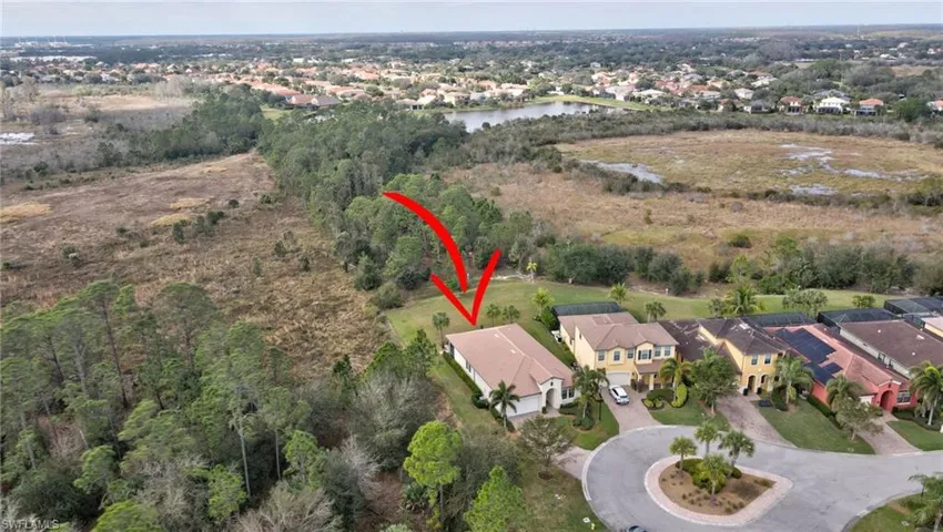 Aerial view of property and surrounding area with nearby suburban area and a nearby body of water