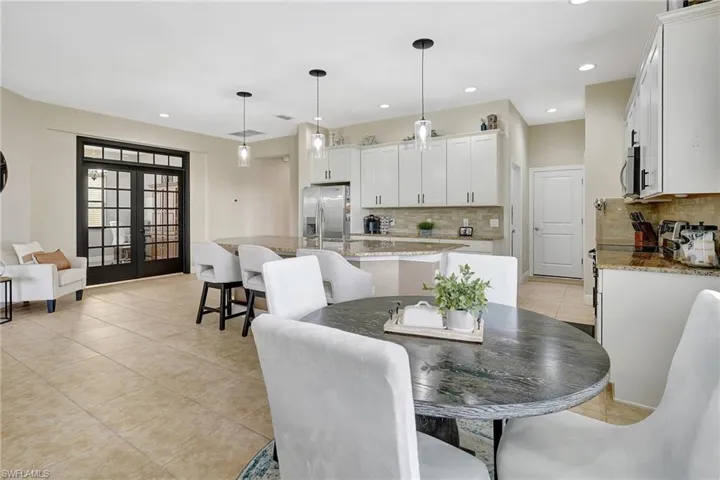 Dining room featuring light tile patterned flooring, recessed lighting, and french doors