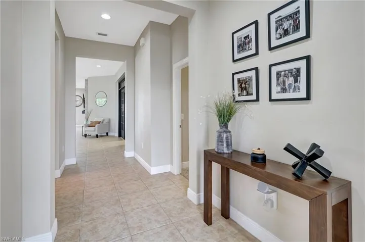 Hall with light tile patterned floors and recessed lighting