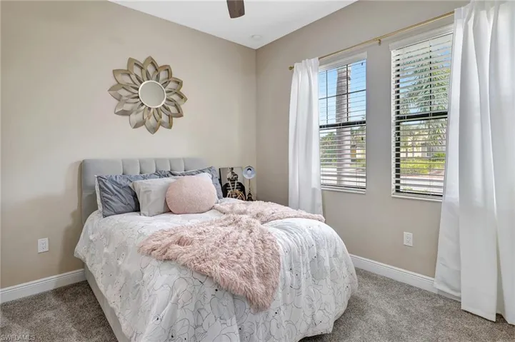 Bedroom with light carpet and a ceiling fan