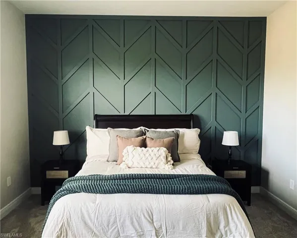 Carpeted primary bedroom featuring custom designed accent wall