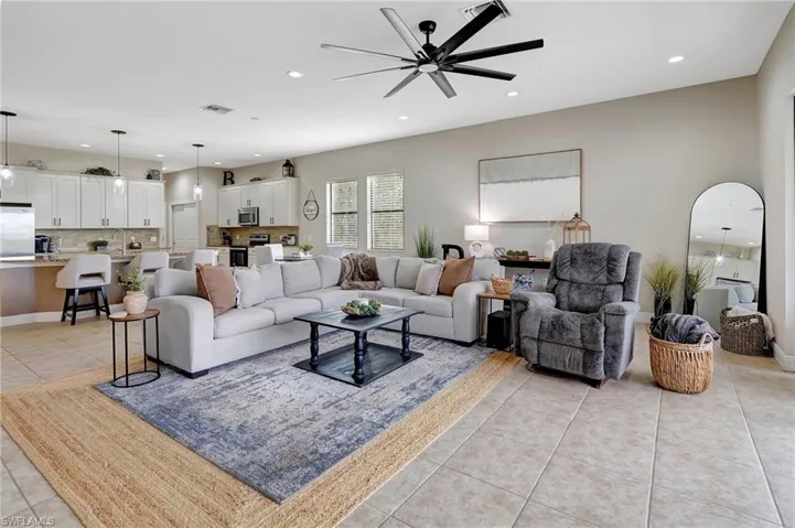 Living area with light tile patterned floors, recessed lighting, and a ceiling fan