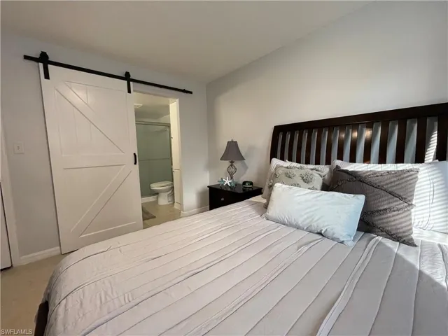 Bedroom featuring ensuite bathroom and a barn door