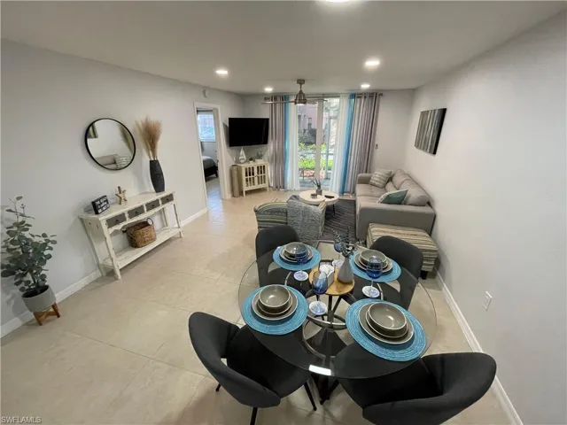 Dining room with light tile patterned floors and recessed lighting