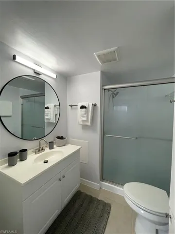 Full bathroom with vanity, a stall shower, and light tile patterned flooring