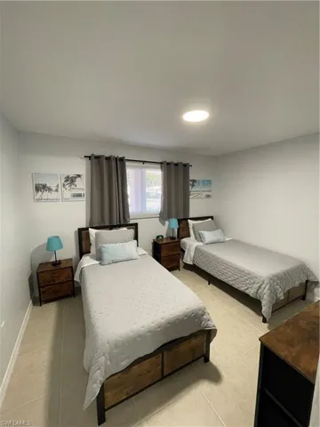 Bedroom featuring light tile patterned floors and baseboards