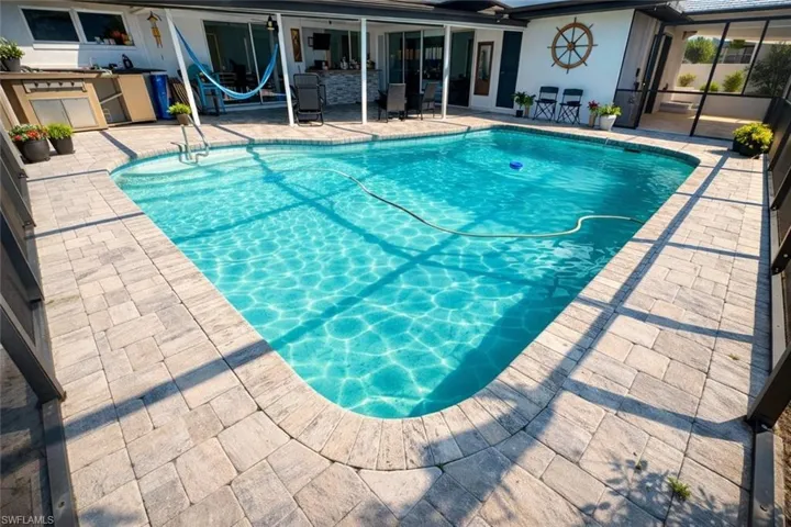 Outdoor pool with an outdoor kitchen and a patio