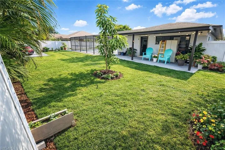 Fenced backyard featuring a lanai and a patio