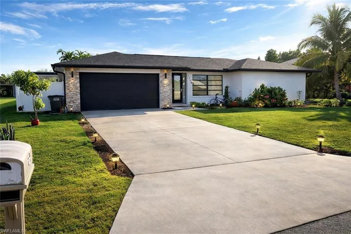 View of front of home with a front yard, concrete driveway, stucco siding, an attached garage, and a shingled roof