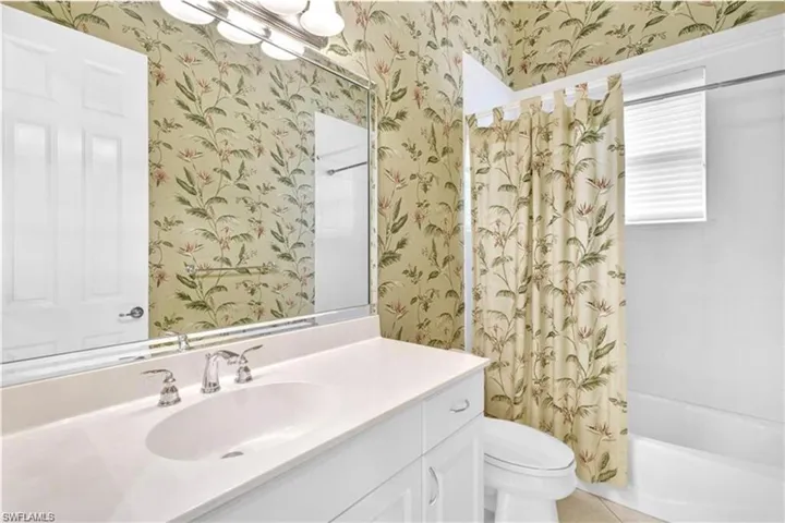 Full bathroom featuring vanity, tile patterned flooring, toilet, and shower / bath combination with curtain