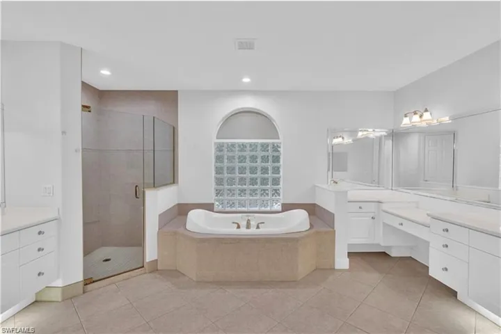 Bathroom with independent shower and bath, vanity, and tile patterned floors
