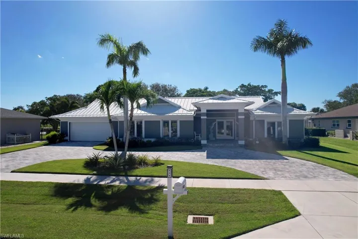 Ranch-style home featuring metal roof, a garage, french doors, a standing seam roof, and a front yard
