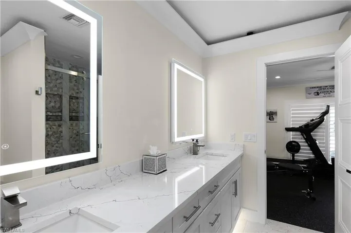 Full bathroom with a stall shower, visible vents, a sink, and double vanity