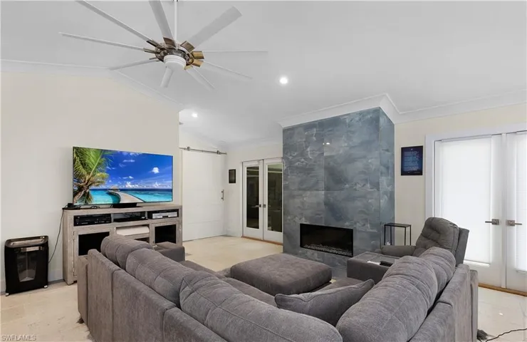 Living area featuring a high end fireplace, french doors, lofted ceiling, and a barn door