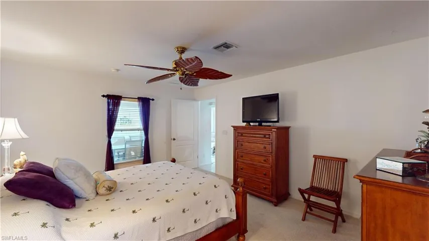 Carpeted bedroom featuring ceiling fan