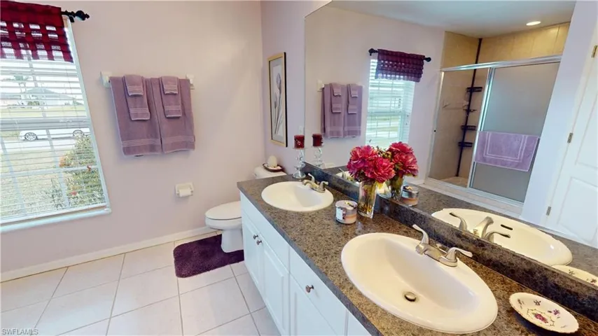 Bathroom with tile patterned flooring, vanity, an enclosed shower, and toilet