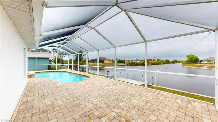 View of swimming pool with a lanai, a patio, and a water view