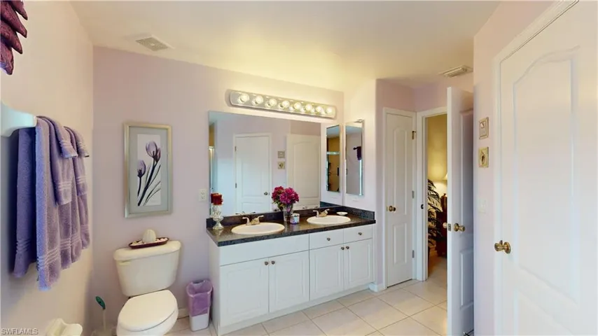 Bathroom featuring tile patterned flooring, vanity, and toilet