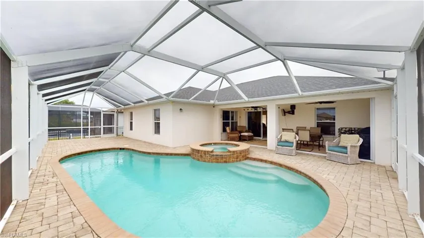 View of swimming pool with an in ground hot tub, a lanai, an outdoor living space, ceiling fan, and a patio