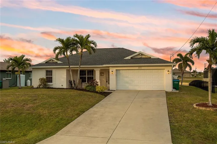 Single story home featuring a yard and a garage