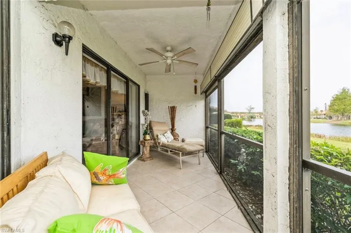 Sunroom featuring ceiling fan and a water view