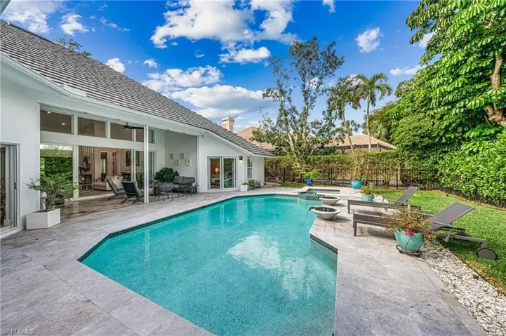 View of pool with a patio and an in ground hot tub