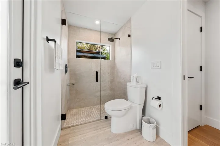 Bathroom featuring toilet, hardwood / wood-style flooring, and walk in shower