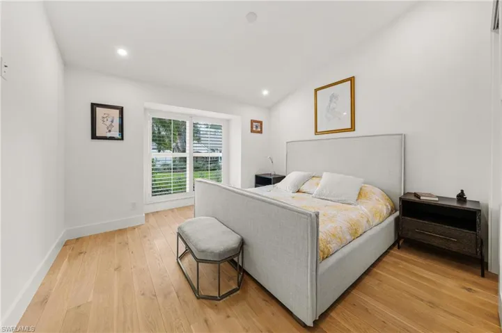 Bedroom featuring light wood-type flooring and vaulted ceiling