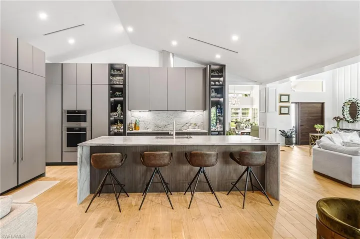 Kitchen with gray cabinets, a breakfast bar, and a large island