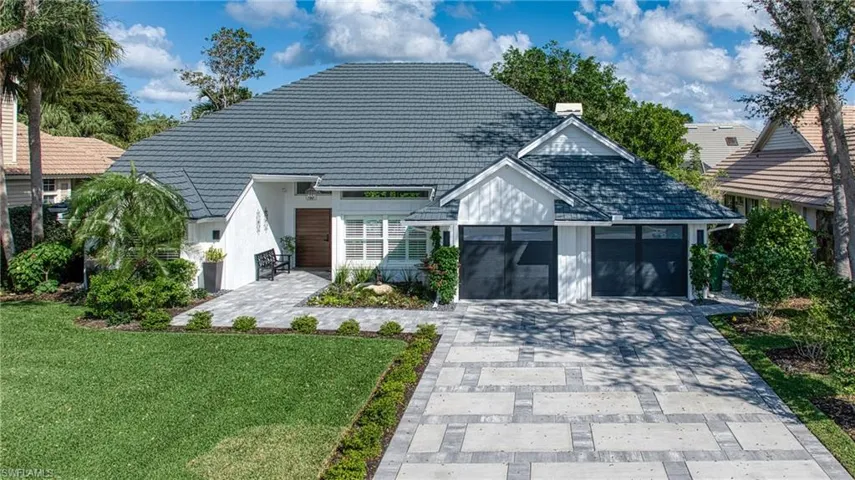 View of front of property featuring a front lawn and a garage