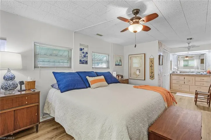 Bedroom with light hardwood / wood-style flooring, multiple windows, sink, and ceiling fan