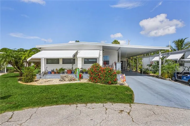 Manufactured / mobile home with a carport and a front yard