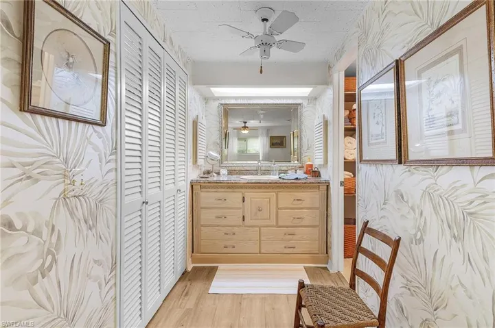 Bathroom with vanity, ceiling fan, and hardwood / wood-style flooring