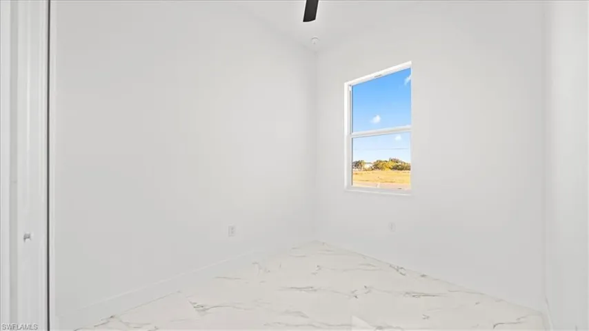 Spare room featuring a ceiling fan and light marble finish floors