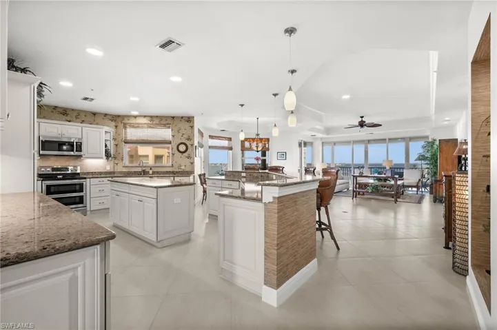 Kitchen featuring a center island, appliances with stainless steel finishes, hanging light fixtures, and plenty of natural light