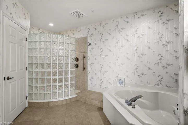 Bathroom featuring independent shower and bath and tile patterned flooring