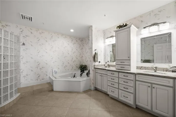 This Primary Bathroom features everything you need!! A huge glass shower with multiple shower heads, a nice tub and lots of storage and cabinets for your convenience!