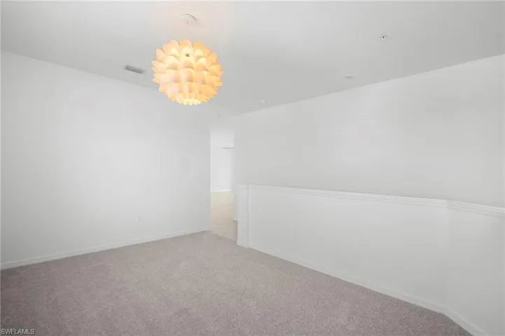 Carpeted empty room with baseboards