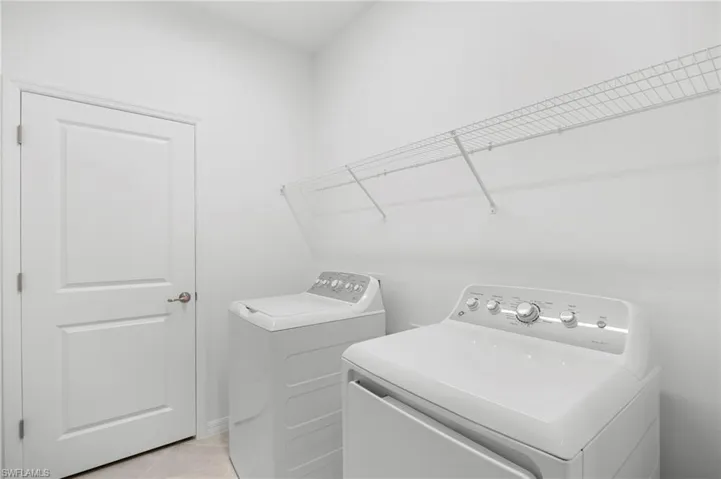 Washroom featuring independent washer and dryer and light tile patterned floors