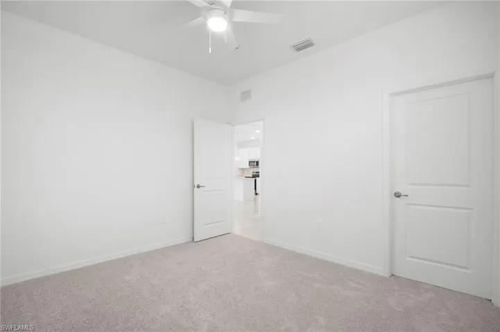 Unfurnished bedroom featuring light colored carpet and a ceiling fan