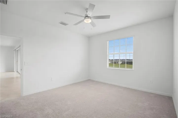 Spare room featuring light colored carpet and ceiling fan